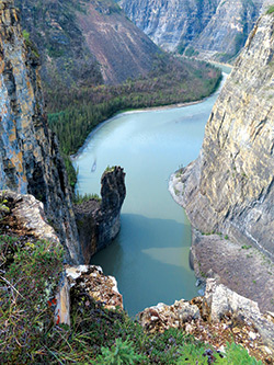 A high up view looking down at a calm river within a canyon